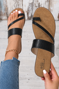 Sandalias negras con la uña de la mano blanca